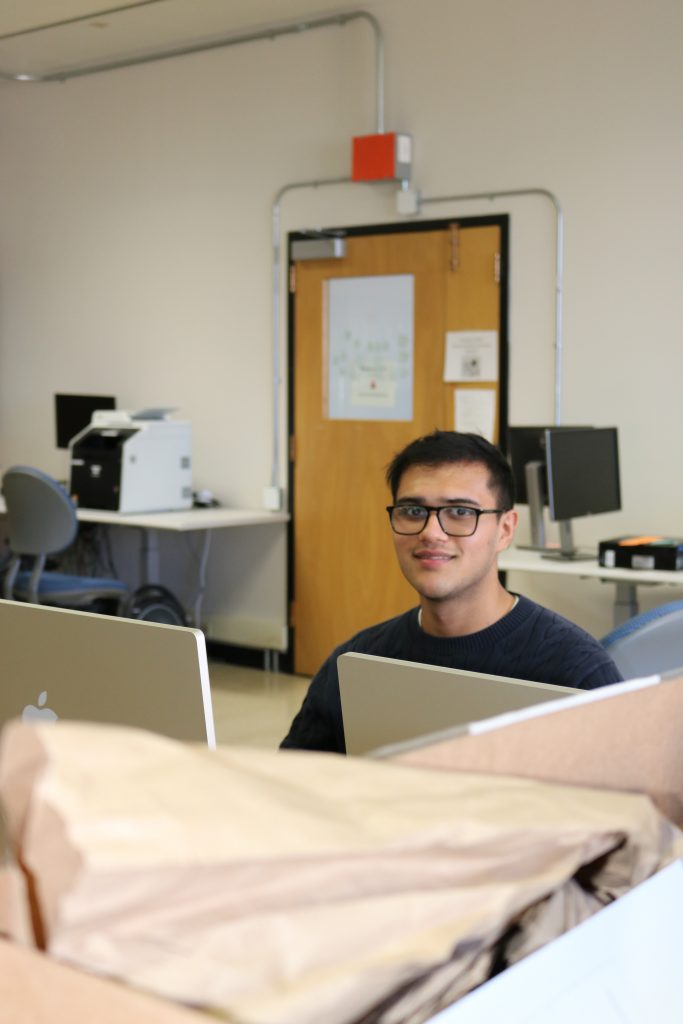 A person sits behind a computer 