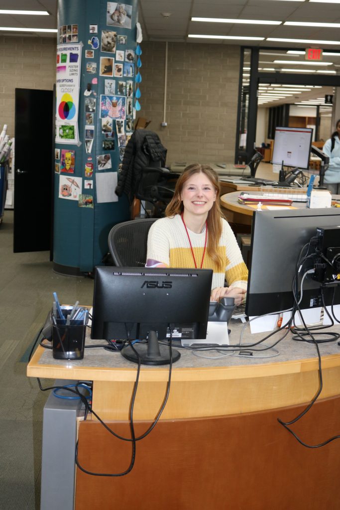 A person sits behind a computer 